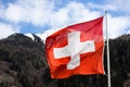 a swiss flag in front of a mountain Royalty Free Stock Photo