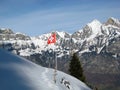 Swiss flag in front of Swiss Alps in winter