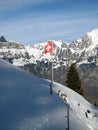 Swiss flag in front of Swiss Alps in winter Royalty Free Stock Photo