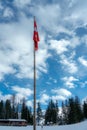 The Swiss flag hangs limply in calm winter air