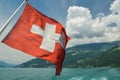 Swiss flag winding in the wind on lake Thun