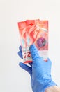 20 Swiss franc banknotes in hand in surgical gloves