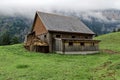 Swiss mountain stable on a green spring meadow with big manure pile in front of the house, manure is good for farming, this house