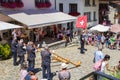 A Swiss musician group play the traditioanl music instrument alphorn with a flag bearer