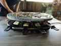 Swiss raclette. A table filled with meat. Raclette machine with a surface for frying and marble plate. Swiss raclette or the Dutch