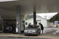 Swiss and traveler people fill oil to tank of car in petrol station Royalty Free Stock Photo