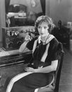 Switchboard operator sitting at telephone switchboard and talking Royalty Free Stock Photo