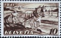 Switzerland - Circa 1941: a postage stamp printed in the Switzerland showing an antique depiction of a farmer in the field with a