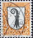 Switzerland - Circa 1923: a postage stamp printed in the Switzerland showing a white coat of arms with a stylized crook of the Swi