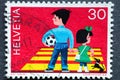 Switzerland - Circa 1969 : a postage stamp printed in the swiss showing a boy with a soccer ball and a girl on the one with a bow