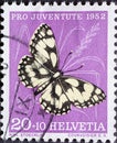 Switzerland - Circa 1952 : a postage stamp printed in the swiss showing a butterfly board Agapetes galathea on a blade of grass