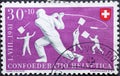 Switzerland - Circa 1951 : a postage stamp printed in the swiss showing three traditional whip throwers in costume. Hornussen The