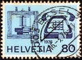 SWITZERLAND - CIRCA 1976: A stamp printed in Switzerland issued for the telephone centenary shows telephones of 1876 and 1976 Royalty Free Stock Photo