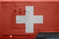 Switzerland flag depicted on side part of military armored truck closeup. Army forces conceptual background