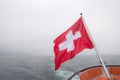 Switzerland flag over Lucerne or Luzern lake with heavy fog cove