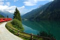 Switzerland:July 2012, Swiss Mountain Train Bernina Express at Lake of Poschiavo.