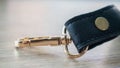 Swivel carabiner fastener with leather black bag strap on a wooden background. Metal carabiner with swivel clip or hook. Small
