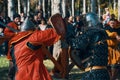 A sword fight in front of a crowd of spectators.