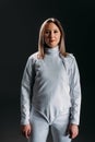 Swordswoman in fencing suit looking at