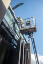 Workman hoisted using a mechanical crane to a high level