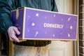 Delivery man holding Dinnerly meal kit in a box near the front door