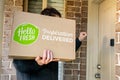 Delivery man holding Hello Fresh meal kits in a box near the front door Royalty Free Stock Photo