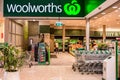 Entrance and exterior view of Woolworths supermarket. Shopping trolleys.
