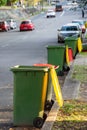 Garbage wheelie bins with colourful lids for recycling and general household waste lined up on the