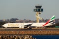 Emirates Boeing 777 aircraft in front of the air traffic control tower at Sydney Airport