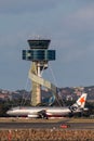 Jetstar Airways Airbus A320 twin engine passenger aircraft taxis past the air traffic control tower at Sydney Airport