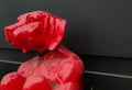 Red dog on human body sculptures sitting, is an artwork display by Gillie and Marc gallery.