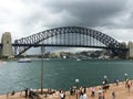Sydney Harbour bridge with Australian and Aboriginal flags and group of tourists