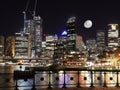 Sydney harbour and CBD illuminated by the moon and circular quay with vibrant colourful