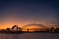 Sydney, New South Wales / Australia - May 17th 2016: Sydney Opera House lit up with light at night time with Harbour Bridge to the Royalty Free Stock Photo