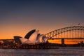 Sydney Opera House lit up with light at night time with Harbour Bridge to the Royalty Free Stock Photo