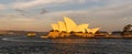 Sydney Opera House at sunset. Boat sailing by it