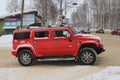 10-02-2020 Syktyvkar, Russia. Red SUV Hammer side view rides on a snowy road in winter in Russia