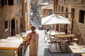 Sylish woman walks on narrow and cozy street in old town of Siena city