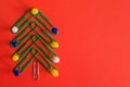 Symbol Christmas tree made of stationery, paper clips, office supplies on red background. new year`s concept in office