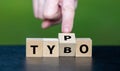 Symbol for correcting a typo. Hand turns dice and corrects the expression tybo to typo