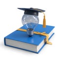 Graduation cap on a lightbulb atop a blue book, isolated on white background Royalty Free Stock Photo