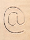 AT symbol, email address icon drawn on sand