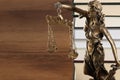 Symbol of fair treatment under law. Figure of Lady Justice and books on wooden table, closeup with space for text