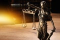 Symbol of fair treatment under law. Statue of Lady Justice on wooden table, space for text