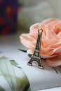 Miniature Eiffel tower in silver on the background of a blooming pink rose Royalty Free Stock Photo