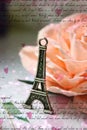 Miniature Eiffel tower in silver on the background of a blooming pink rose Royalty Free Stock Photo