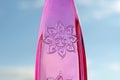 Symbol Happiness on a pink glass bottle against a blue sky.