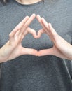 A symbol of the heart with the fingers of a female hand.