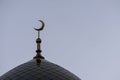 The symbol of Islam is a golden crescent moon on top of the mosque minaret on the blue evening of the morning sky. Royalty Free Stock Photo