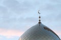 The symbol of Islam is a golden crescent moon on top of the mosque. Minaret on the blue evening of the morning sky with clouds. Royalty Free Stock Photo